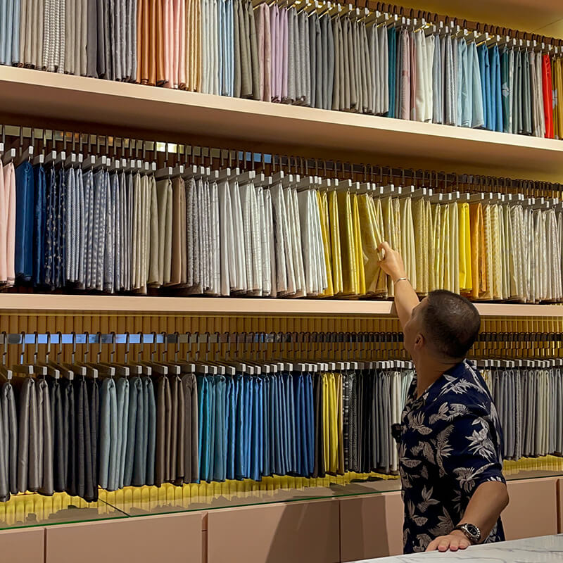 Chef Zam Looking Though Curtain Library's Fabric Collection